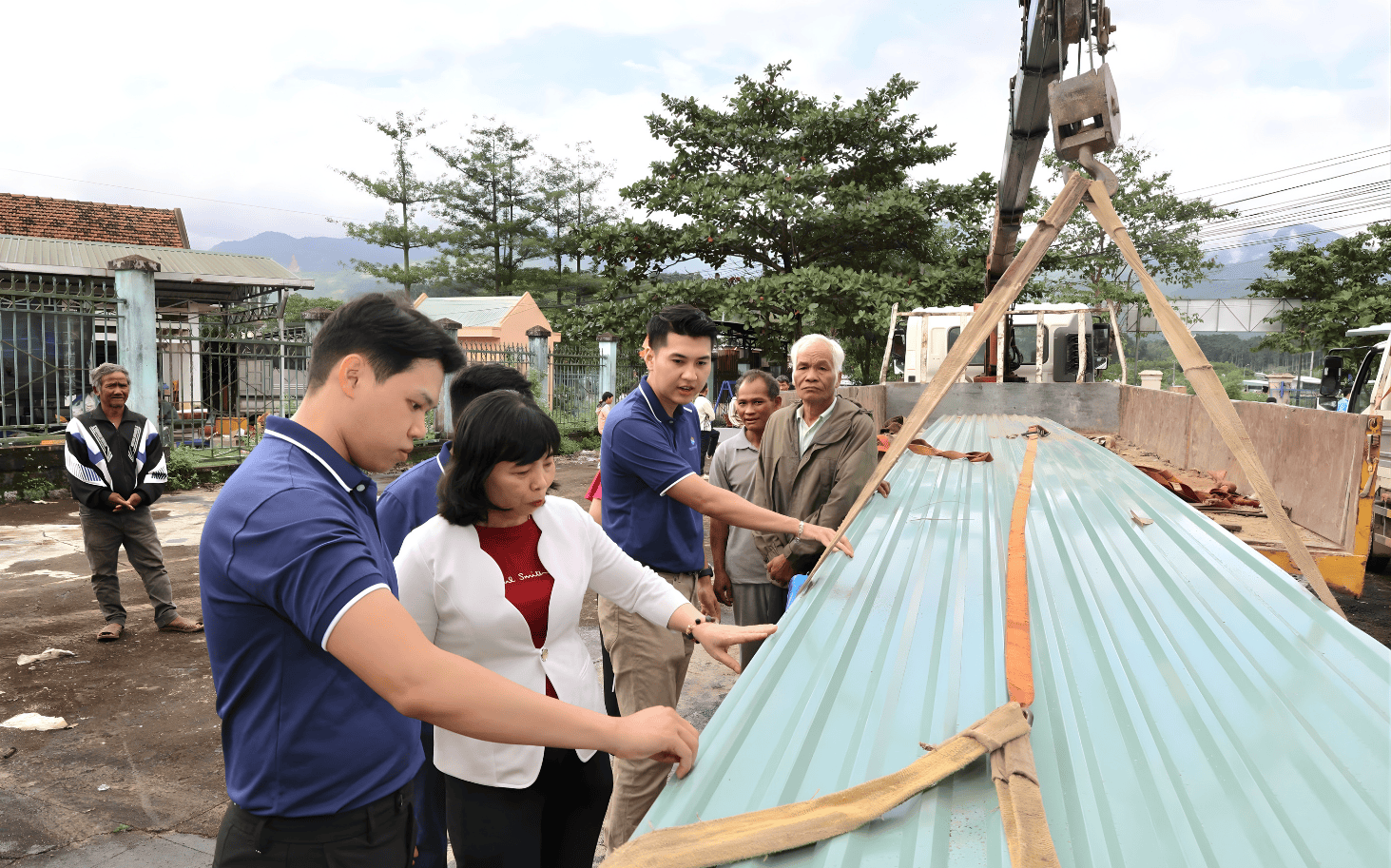 Đại diện Tôn Phú Mỹ phối hợp cùng địa phương thực hiện quy trình bàn giao tôn lợp mái